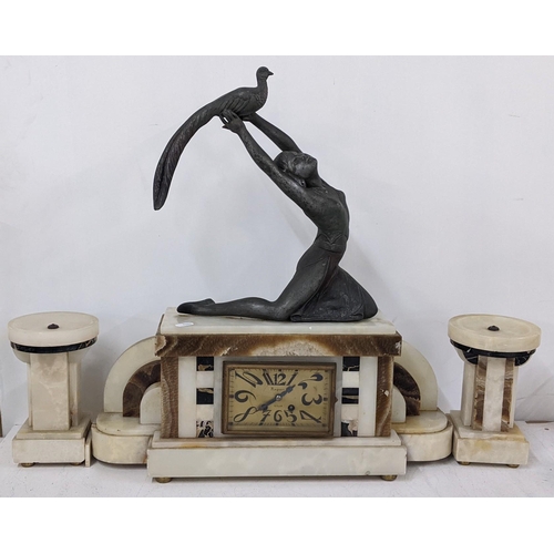 214 - An Art Deco French marble clock garniture surmounted by a spelter figure of a lady holding a bird, 8... 