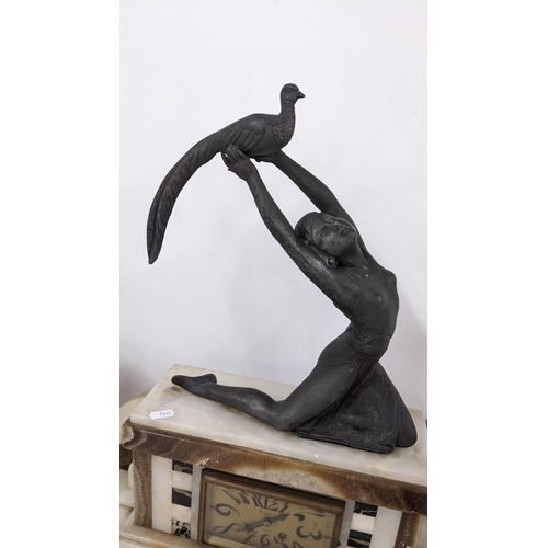 214 - An Art Deco French marble clock garniture surmounted by a spelter figure of a lady holding a bird, 8... 