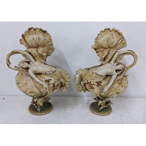 218 - A pair of circa 1900 Royal Dux vases fashioned as nude females relining on the bulbous floral bodies... 