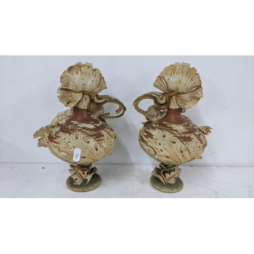 218 - A pair of circa 1900 Royal Dux vases fashioned as nude females relining on the bulbous floral bodies... 