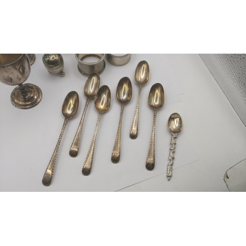 140 - A mixed lot of mostly silver items to include two napkin rings, two egg cups, silver spoon 138.1g, t... 