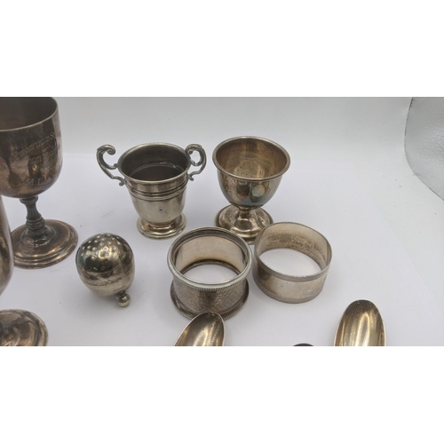 140 - A mixed lot of mostly silver items to include two napkin rings, two egg cups, silver spoon 138.1g, t... 