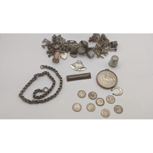 141 - Silver to include a charm bracelet with a quantity of silver and white metal charms, a Victorian whi... 