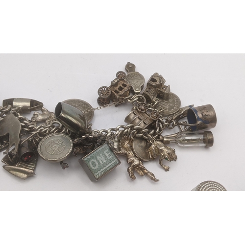 141 - Silver to include a charm bracelet with a quantity of silver and white metal charms, a Victorian whi... 