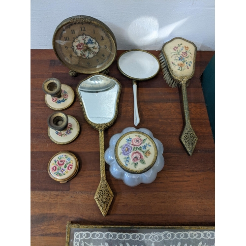 377 - A dressing table set with embroidered ornament, tray, clock, brushes, mirror, candlestick and an ebo... 