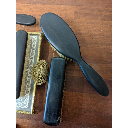 377 - A dressing table set with embroidered ornament, tray, clock, brushes, mirror, candlestick and an ebo... 