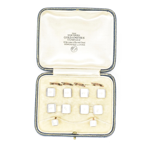 242 - A 9ct yellow and white gold dress shirt set, each having a seed pearl centre, mother of pearl and ma... 