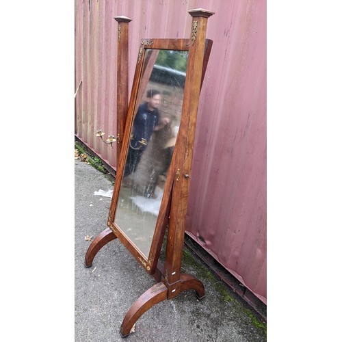 245 - A 19th century French empire cheval mirror, the swing mirror supported by two tapering columns and e... 