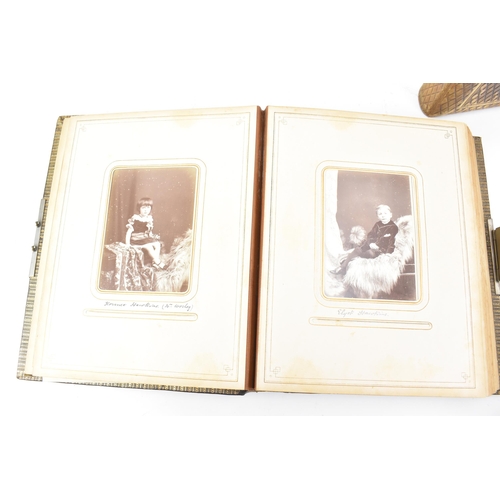 125 - Three photograph albums to include a Victorian leather bound example, the front cover applied with g... 