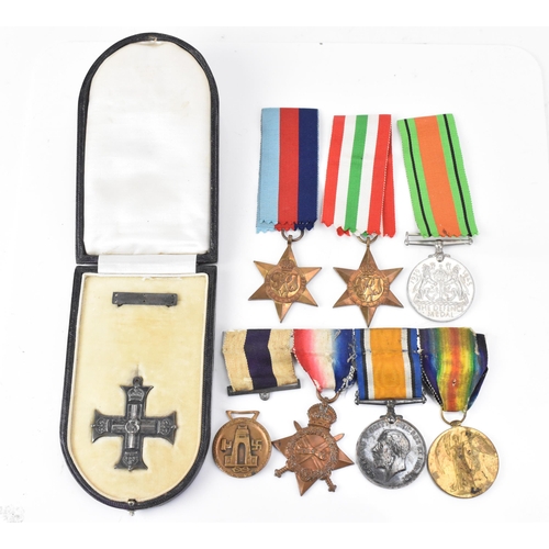 131 - A WWI and WWII medal group to include a cased military cross, 1914/15 star, War and Victory medal na... 