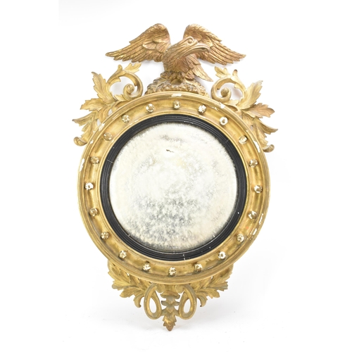 236 - A Regency wall mirror, having a convex plate in a gilt moulded and carved giltwood frame with a ball... 