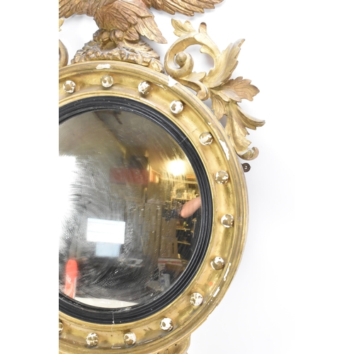 236 - A Regency wall mirror, having a convex plate in a gilt moulded and carved giltwood frame with a ball... 