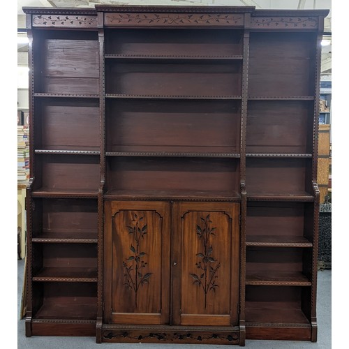 250 - A late Victorian Aesthetic mahogany open breakfront bookcase, having a moulded cornice, loose shelve... 