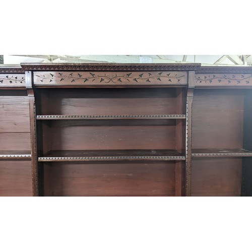 250 - A late Victorian Aesthetic mahogany open breakfront bookcase, having a moulded cornice, loose shelve... 