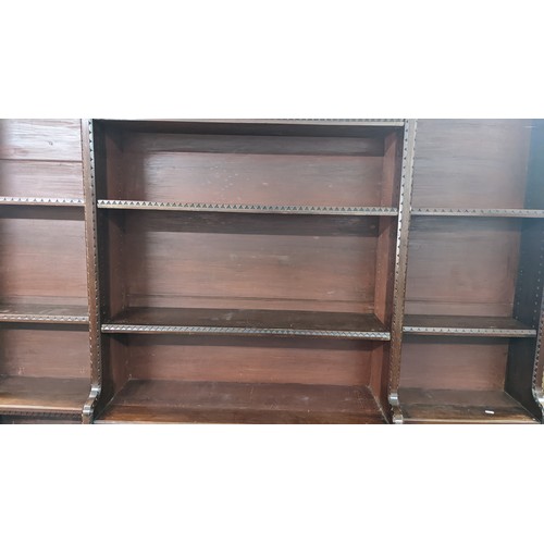 250 - A late Victorian Aesthetic mahogany open breakfront bookcase, having a moulded cornice, loose shelve... 