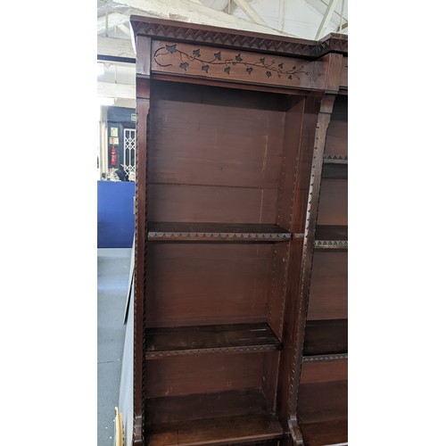 250 - A late Victorian Aesthetic mahogany open breakfront bookcase, having a moulded cornice, loose shelve... 