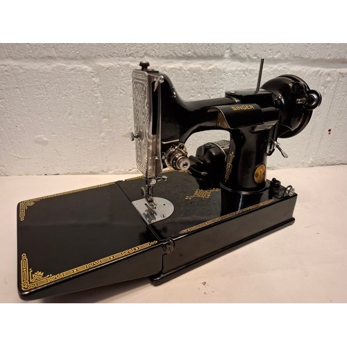 28 - A 1950 Singer 221K electric sewing machine in original fitted case with accessories and manual, seri... 