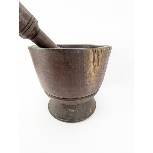 311 - A mid 20th century large hardwood pestle and mortar, on a flared foot, 33cm h, 35cm dia

Location:LA... 