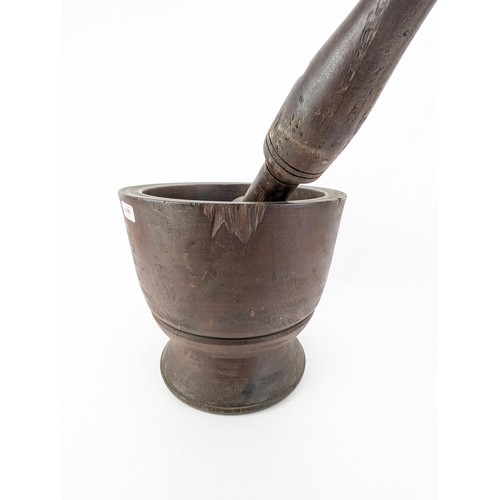 311 - A mid 20th century large hardwood pestle and mortar, on a flared foot, 33cm h, 35cm dia

Location:LA... 