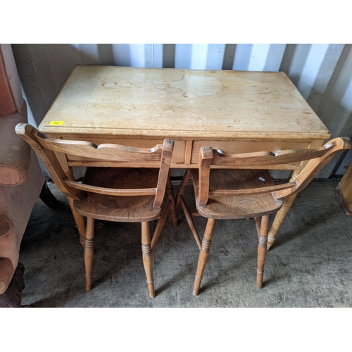 343 - A small pine table with two drawers raised on turned tapered legs along with a pair of light oak din... 