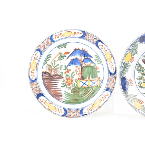 525 - Two 18th century Dutch Delft polychrome plates, one depicting a still life of flowers and a table in... 