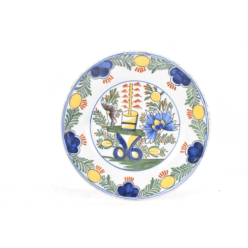 525 - Two 18th century Dutch Delft polychrome plates, one depicting a still life of flowers and a table in... 