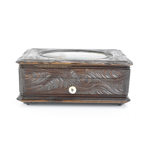 481 - A late 19th century black forest carved music box, the lid inset with an oval oil painting depicting... 