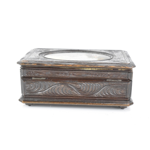 481 - A late 19th century black forest carved music box, the lid inset with an oval oil painting depicting... 