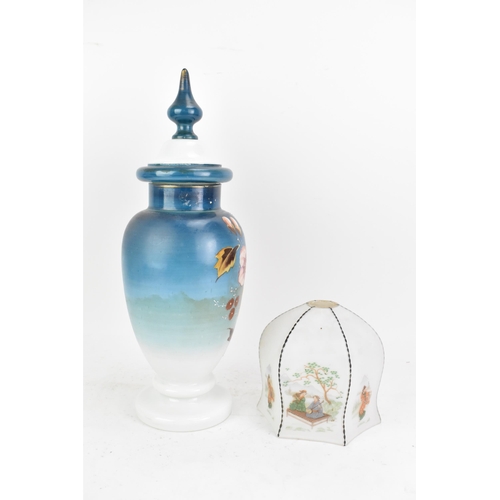 491 - A late 19th century opaline glass lidded vase, having a knopped finial, the ovoid body painted in bl... 