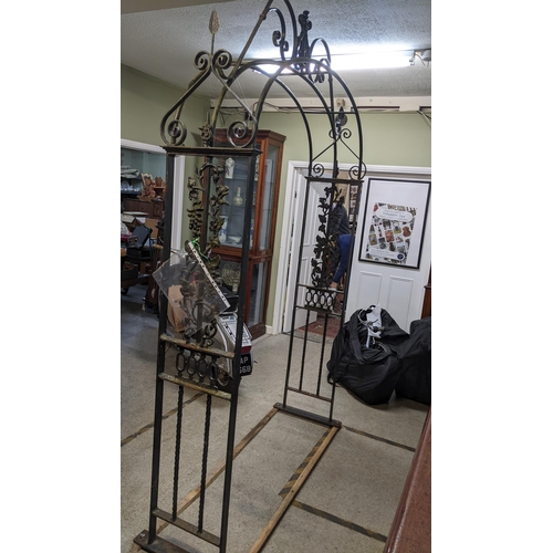 388 - A large cast iron garden arch having a scroll design frame, cast grapevine side panels above barley ... 