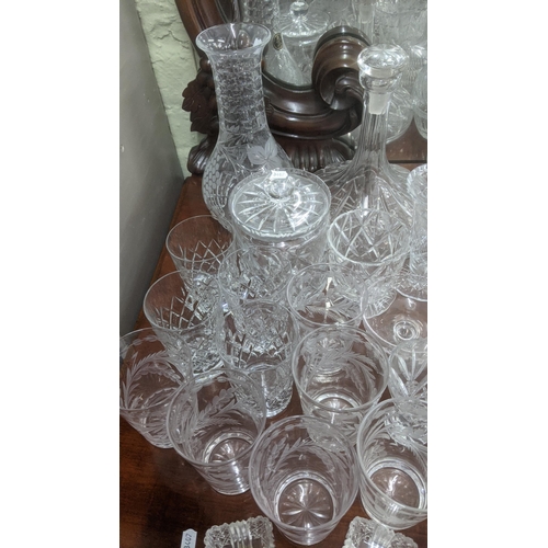 474 - A quantity of glassware to include a variety of crystal cut glass decanters, a pair of wine glasses ... 