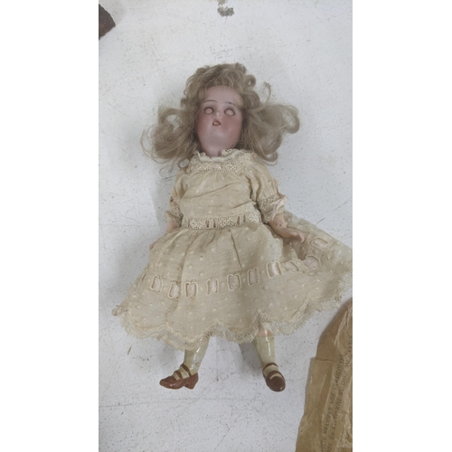 479 - An early 20th century bisque head blue eyed sleeping doll showing teeth on a composite jointed body ... 