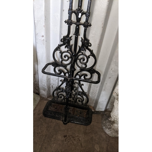 498 - A Victorian style cast iron black painted hallstand having a floral scroll design frame and drip tra... 