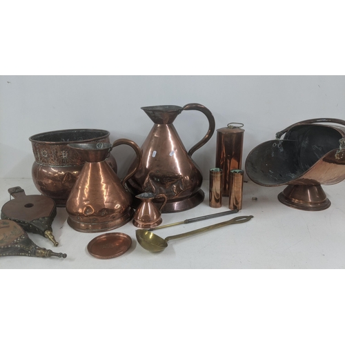 514 - A selection of mainly copper fire side items to include a George III copper helmet coal scuttles, a ... 