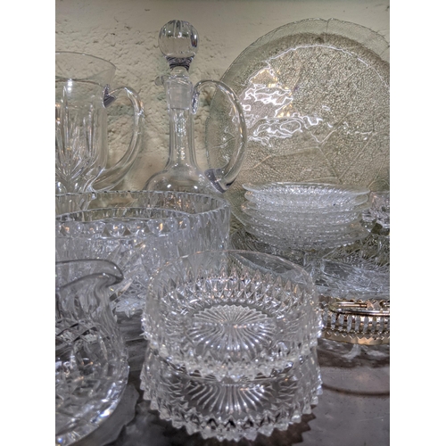 524 - A collection of glassware to include decorative plates, drinking glasses, decanters, serving jugs, b... 