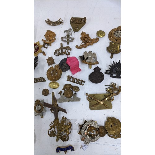 437 - A collection of military cap badges to include Royal Scots Guards, Australian Commonwealth Military ... 