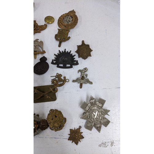 437 - A collection of military cap badges to include Royal Scots Guards, Australian Commonwealth Military ... 