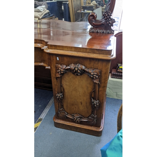 305 - A fine and large Victorian mahogany sideboard carved with vine leaf decoration (closely following th... 