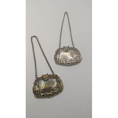 11 - Two silver cast decanter labels to include a Brandy label decorated as a fox, hounds and a man on ho... 