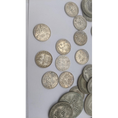 69 - A collection of pre 1946 silver British coinage to include three pence coins, florins and two shilli... 