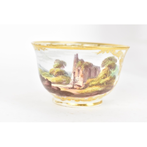 94 - An early 19th century Derby porcelain cup and saucer, circa 1810-20, each decorated with landscape s... 