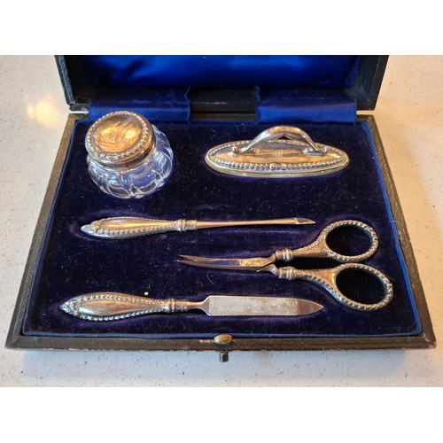 54 - An early 20th Century silver manicure set, the bottle lid, nail buffer and handles engraved with the... 