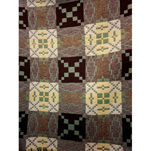 49 - A vintage Welsh woollen blanket in green, black, cream and yellow having a geometric pattern to both... 