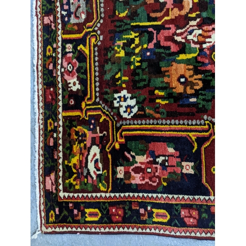 366 - Karabagh French or Ukrainian style rug, hand woven floral design on a pink and red ground, triple gu... 