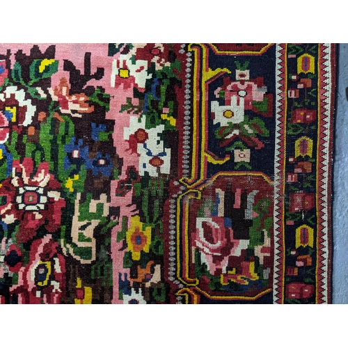 366 - Karabagh French or Ukrainian style rug, hand woven floral design on a pink and red ground, triple gu... 