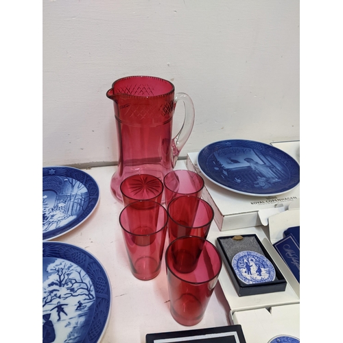 204 - A mixed lot to include Royal Copenhagen Christmas plates; plaques; a cranberry jug; glass set.

Loca... 