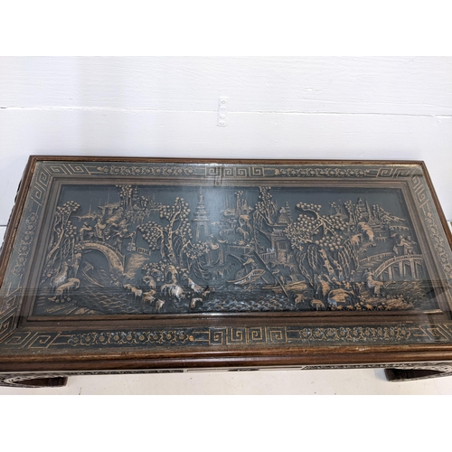 214 - An Oriental South Asian rosewood opium table with an ornate carving, depicting a river scene behind ... 