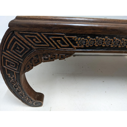 214 - An Oriental South Asian rosewood opium table with an ornate carving, depicting a river scene behind ... 