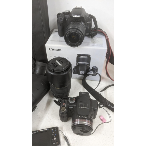 271 - A group of cameras and camera accessories to include a Canon E05 500D and Lumix Fz45 along with Tamr... 