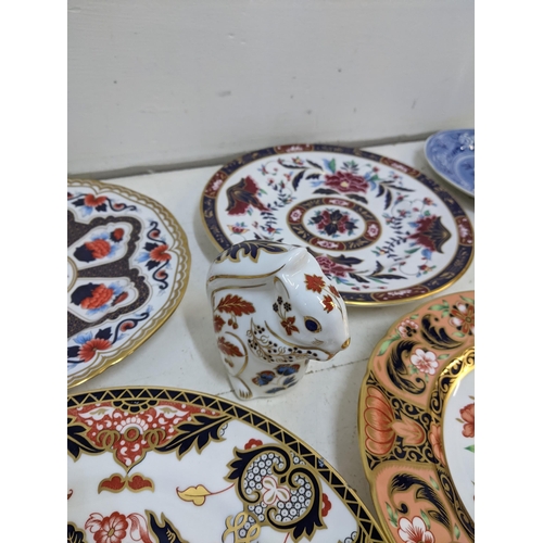 299 - Eight Royal Crown Derby plates to include seconds, a Royal Crown Derby silver stopper squirrel paper... 